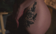 Pormenor de nádega de mulher com tatuagem a pensar em clarear virilha.
