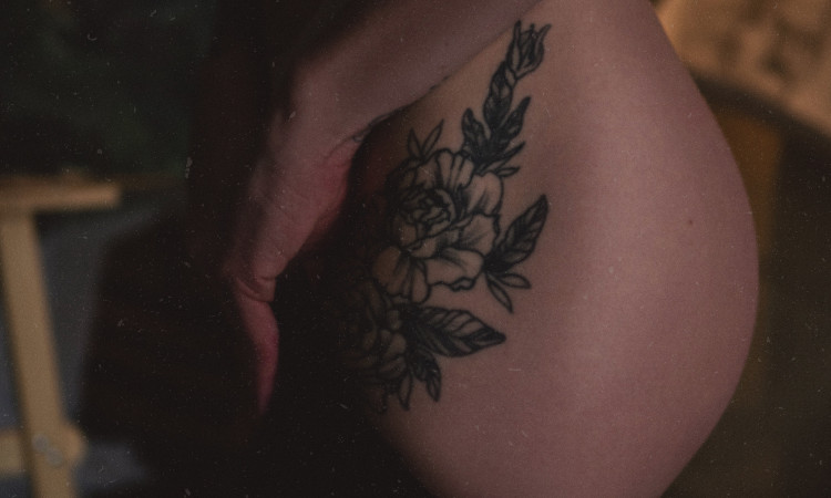 Pormenor de nádega de mulher com tatuagem a pensar em clarear virilha.