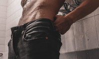 Tronco de homem nu com calças pretas vestidas e semiabertas, pensando em como bater uma punheta.