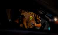 Tronco de policial, sem se ver seu rosto, pedindo documento a homem dentro de carro e explicando que fazer sexo na rua é crime.