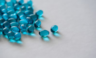 Comprimidos azuis espalhados em fundo cinzento em experiência sobre quem não pode tomar Viagra.