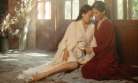 Sexo entre mulheres maduras com duas asiáticas em clima de intimidade, uma usando um roupão vermelho e a outra branco.