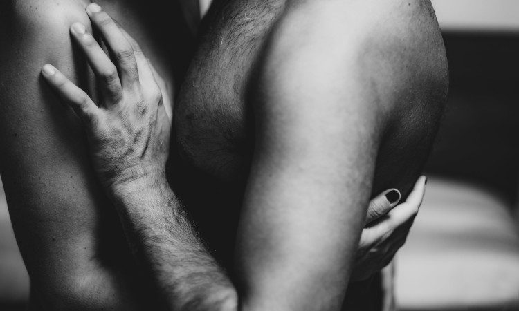 Troncos de mulher e homem despidos se abraçando numa fotografia a preto e branco pensando em sexo sem penetração.