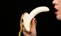 Boca de mulher se abrindo em direção a uma banana descascada que está segurando na mão enquanto pensa nos tipos de sexo oral.