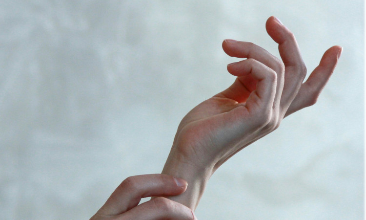 Mão delicada estendida no ar em posição de quem está pensando em como dedar o cu.